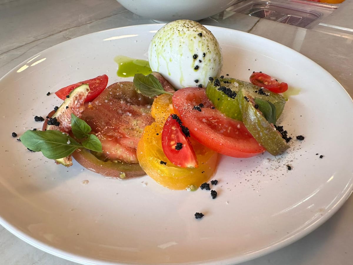 Burrata fraîche avec tomates anciennes, basilic et huile d’olive.